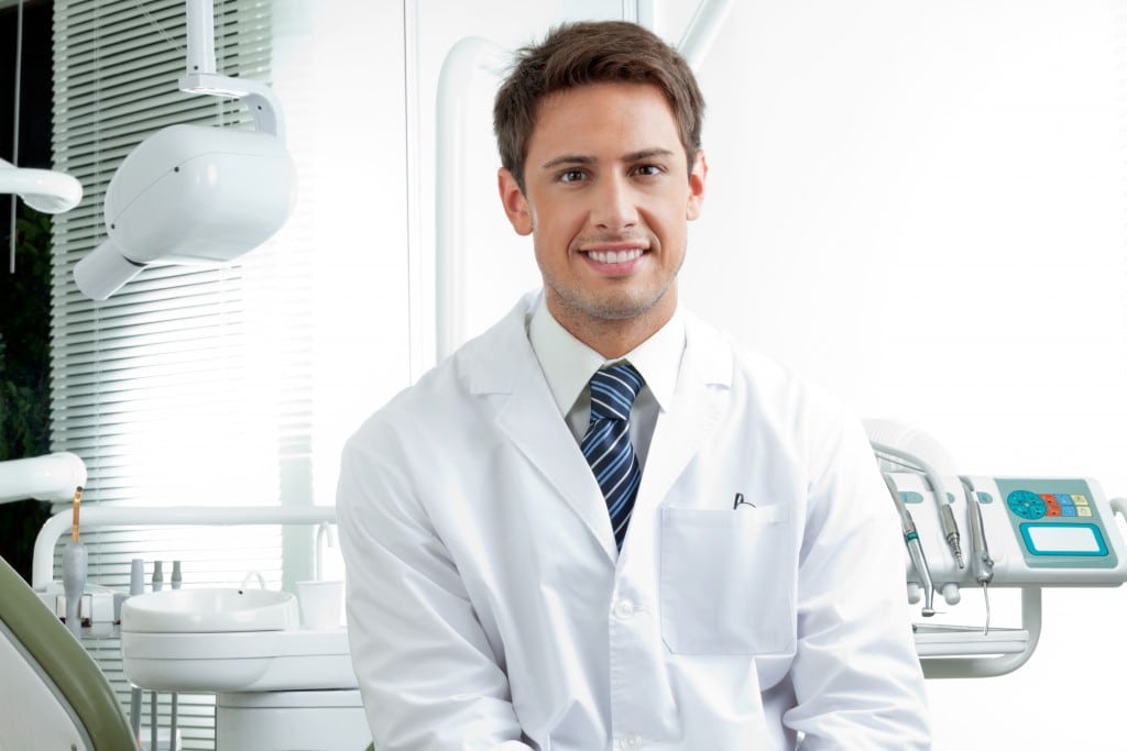 Male dentist in white coat