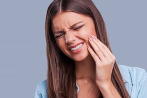 Girl touching face in tooth pain
