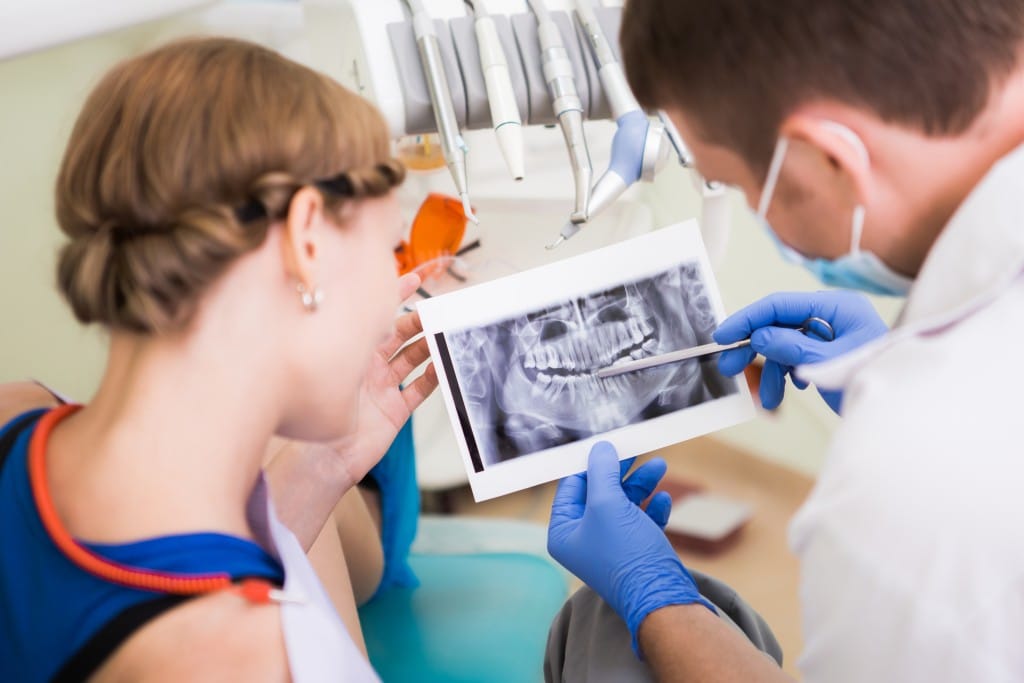 Dentist and patient examining x-ray