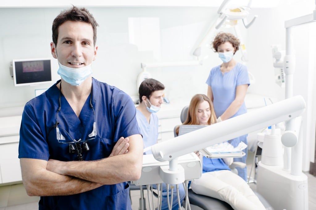 Dentists and assistants speaking with dental patient during dental checkup