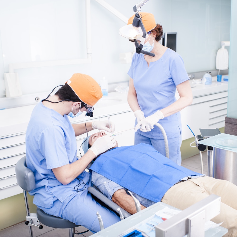 Two dentists working on a patient