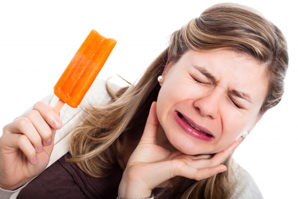 woman with sensitive teeth eating popsicle